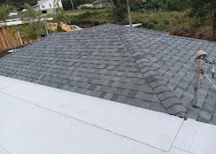 Gray dimensional asphalt shingles installed on residential roof with white fascia trim