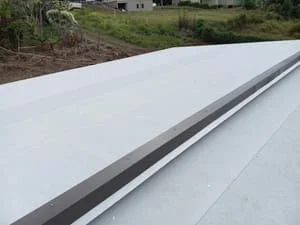 White metal standing seam roof with aluminum gutter and downspout installation