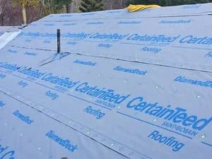 Blue synthetic roof underlayment installed with overlapping seams on roof deck