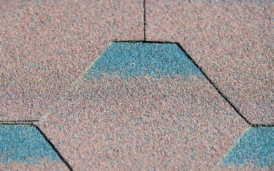 Architectural asphalt shingles with gray, brown, and blue-green coloring installed with proper overlap