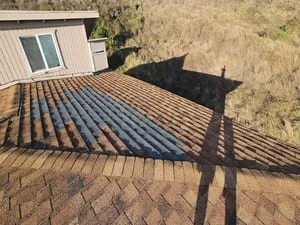 Newly installed dark asphalt shingle roof with dimensional shingles and clean alignment