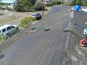 Aerial view of residential roof with new asphalt shingles and underlayment installation in progress