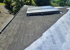 Asphalt shingle roof installation with underlayment and flashing on pitched residential roof