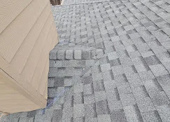Newly installed gray asphalt shingles with proper offset pattern and aligned rows on residential roof