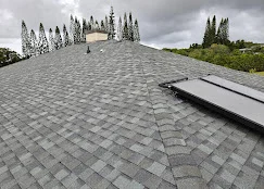 Newly installed gray architectural asphalt shingles on multi-level roof with integrated flashing