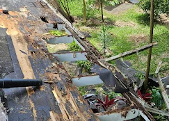 Roof tear-off showing exposed decking, removed shingles, and debris during roofing replacement project
