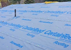 Blue synthetic roof underlayment with printed guidelines installed on roof deck