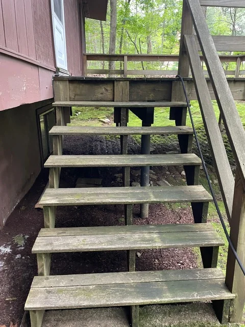 Wooden exterior stairs with metal railings, six treads, weathered finish