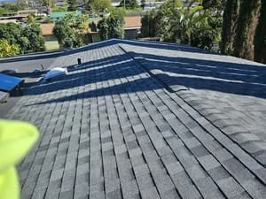 Gray asphalt shingle roof installation with dimensional shingles in staggered pattern