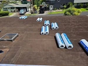 Bundles of dark asphalt shingles staged on residential roof deck during replacement project