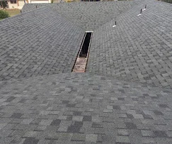 Gray asphalt shingles with skylight flashing on completed roof installation