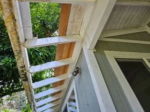 White painted wood soffit and fascia boards installed under roof overhang with ventilation details