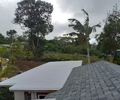 Newly installed gray asphalt shingle roof with ridge caps and proper flashing on residential home
