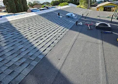 Newly installed asphalt shingle roof with gray dimensional shingles and clean installation lines