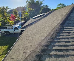 Newly installed asphalt shingle roof with gray architectural shingles on pitched roof