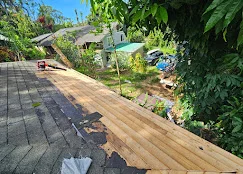 Composite deck with wood framing and adjacent paver patio in residential backyard