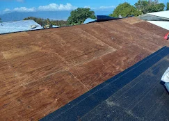 Flat roof with dark membrane installation and protective covering on commercial building