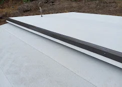 White membrane flat roof with black edge trim and flashing installation
