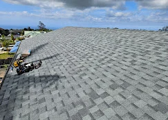 Gray dimensional asphalt shingles installed on pitched roof with proper overlap and alignment