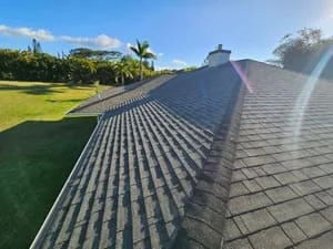 Charcoal gray asphalt shingle roof with ridge caps and proper alignment on residential home