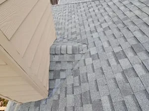 Gray dimensional asphalt shingles installed with proper overlap and alignment on pitched roof