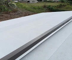 White flat roof membrane with metal trim and flashing installation