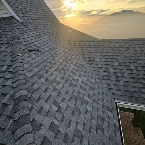 Gray dimensional asphalt shingles installed on multi-plane residential roof with proper overlap and alignment