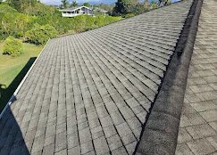 Charcoal gray architectural shingles installed on residential roof with clean ridge lines and proper alignment