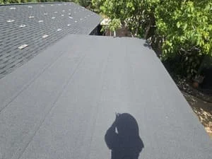 Newly installed asphalt shingle roof with charcoal gray dimensional shingles