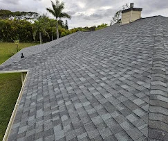 Newly installed gray architectural shingles on residential roof with proper alignment and gutter integration