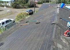 Newly installed asphalt shingle roof with parallel rows and proper shingle overlap