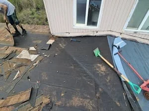 Asphalt shingle roof installation in progress with prepared substrate and roofing materials