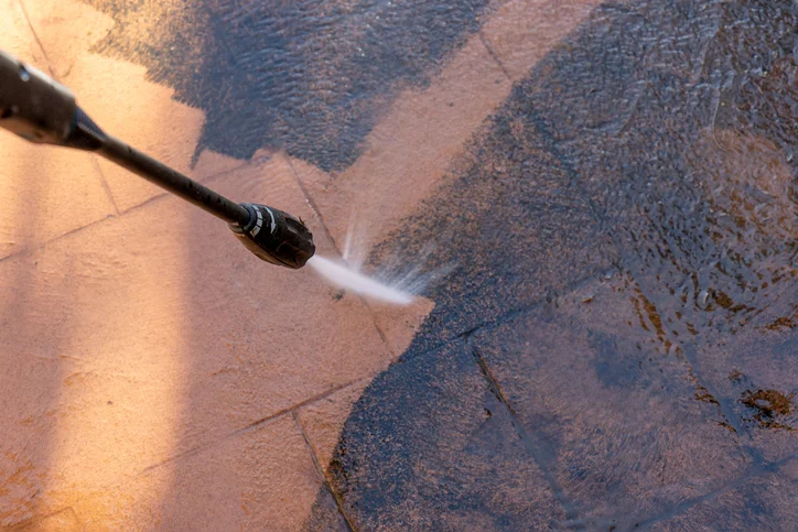 Power washing tile and concrete surfaces with high-pressure spray nozzle