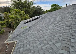 Gray dimensional asphalt shingles installed on residential roof with proper alignment and flashing